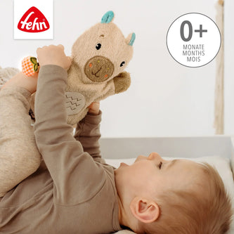Baby spielt mit weichem Capybara Waschhandschuh von Fehn für Babys ab Geburt