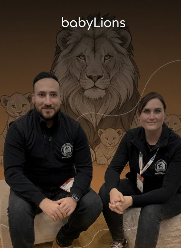 Gründer von BabyLions® präsentieren hochwertige Baby- und Kinderprodukte vor Löwen-Markenmotiv – Familienmarke für liebevolle Geschenkideen zur Geburt.