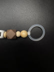 Nahaufnahme des Silikonrings der personalisierten Schnullerkette Bär mit Namen von BabyLions® mit brauner Silikonperle, Holzperlen und hochwertigem Schnulleradapter