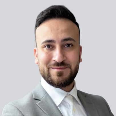 Porträtfoto des Gründers von BabyLions im hellgrauen Anzug mit weißem Hemd vor einfarbig grauem Hintergrund – professionelle Vorstellung im Teamprofil.