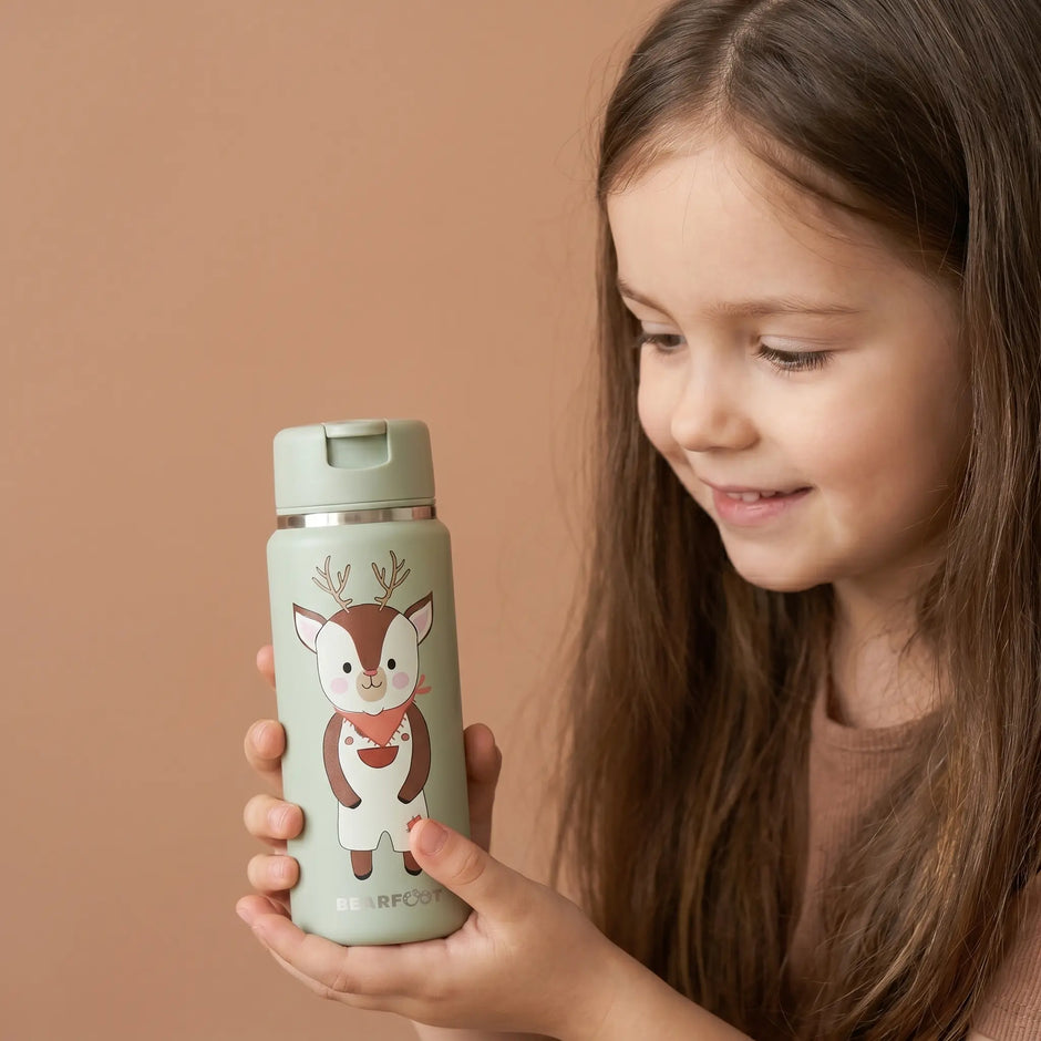 Kind hält BEARFOOT TINY Thermo Kinder Trinkflasche Reh 200 ml aus Edelstahl mit handgezeichnetem Reh-Design Liv – auslaufsichere Kinder-Trinkflasche für Kindergarten und unterwegs