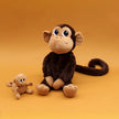 Affenmama und Baby Affe als kuschelige Plüschtiere vor orangem Hintergrund