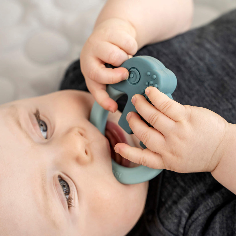 Baby kaut auf blauem Silikon Beißring Deer Friends