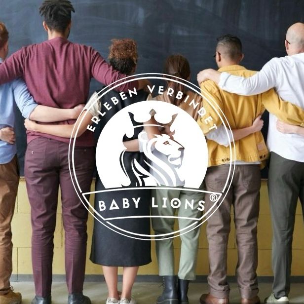 Menschen stehen Arm in Arm vor einer Wand mit BabyLions Logo und Slogan Erleben verbindet
