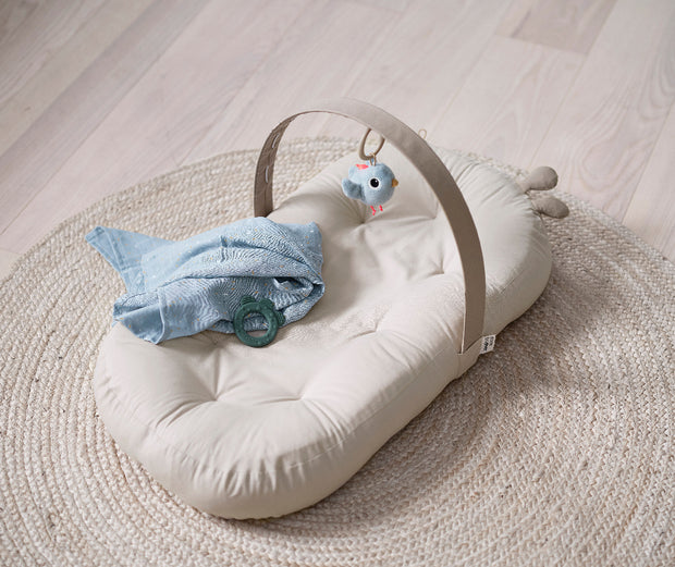 Cozy Lounger mit Aktivitätsbogen Raffi von Done by Deer als bequemes Baby-Nest