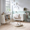 Kinderzimmer mit Babybett und Aktivitätsbogen Raffi Done by Deer auf Spielmatte in ruhiger Umgebung