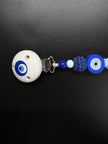 Detailaufnahme des Holzclips und der Häkelperle der personalisierten Schnullerkette Elias mit Bösem Auge