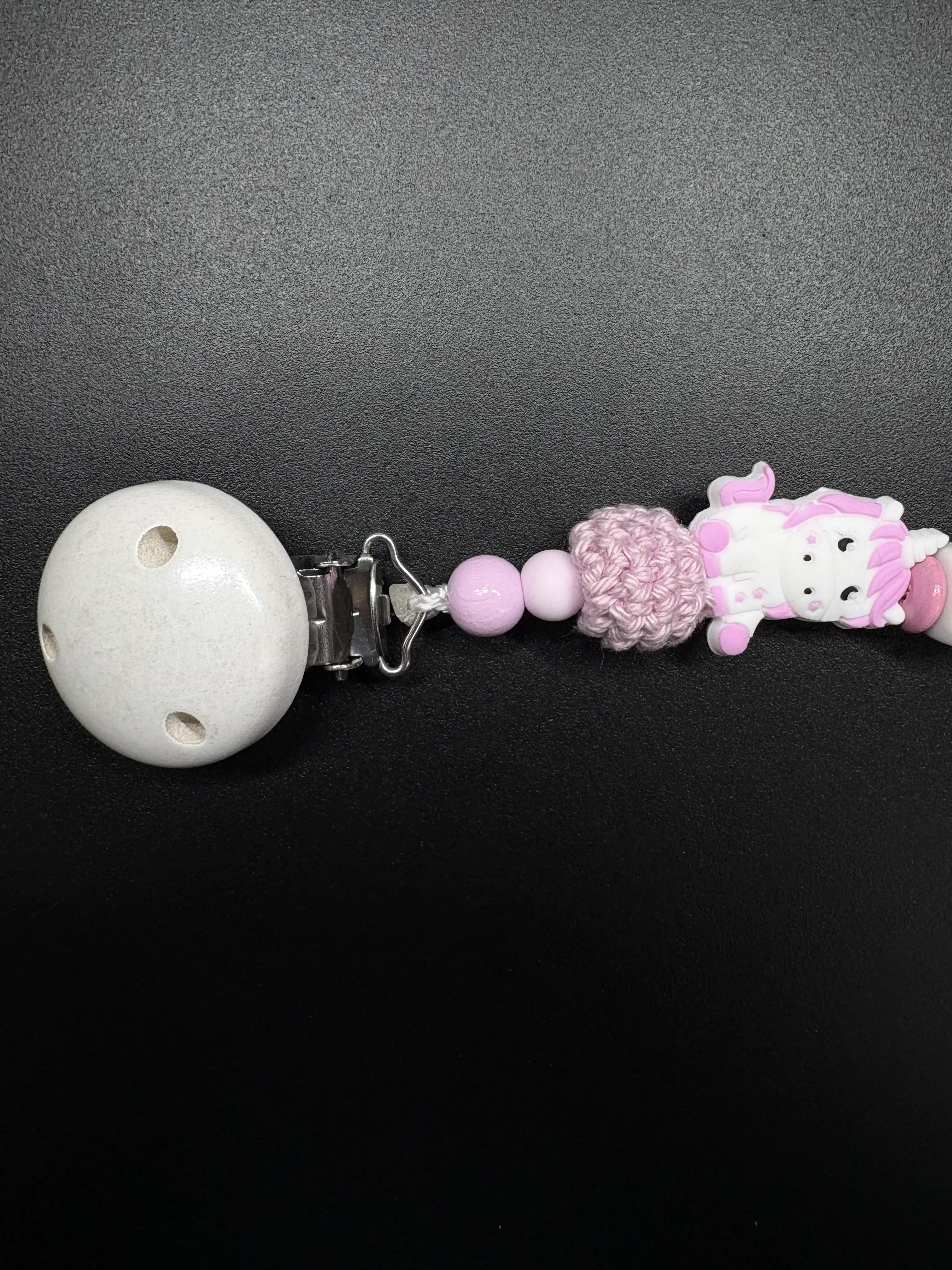 Detailaufnahme des Holzclips der personalisierten Einhorn Schnullerkette Luna in Rosa und Weiß