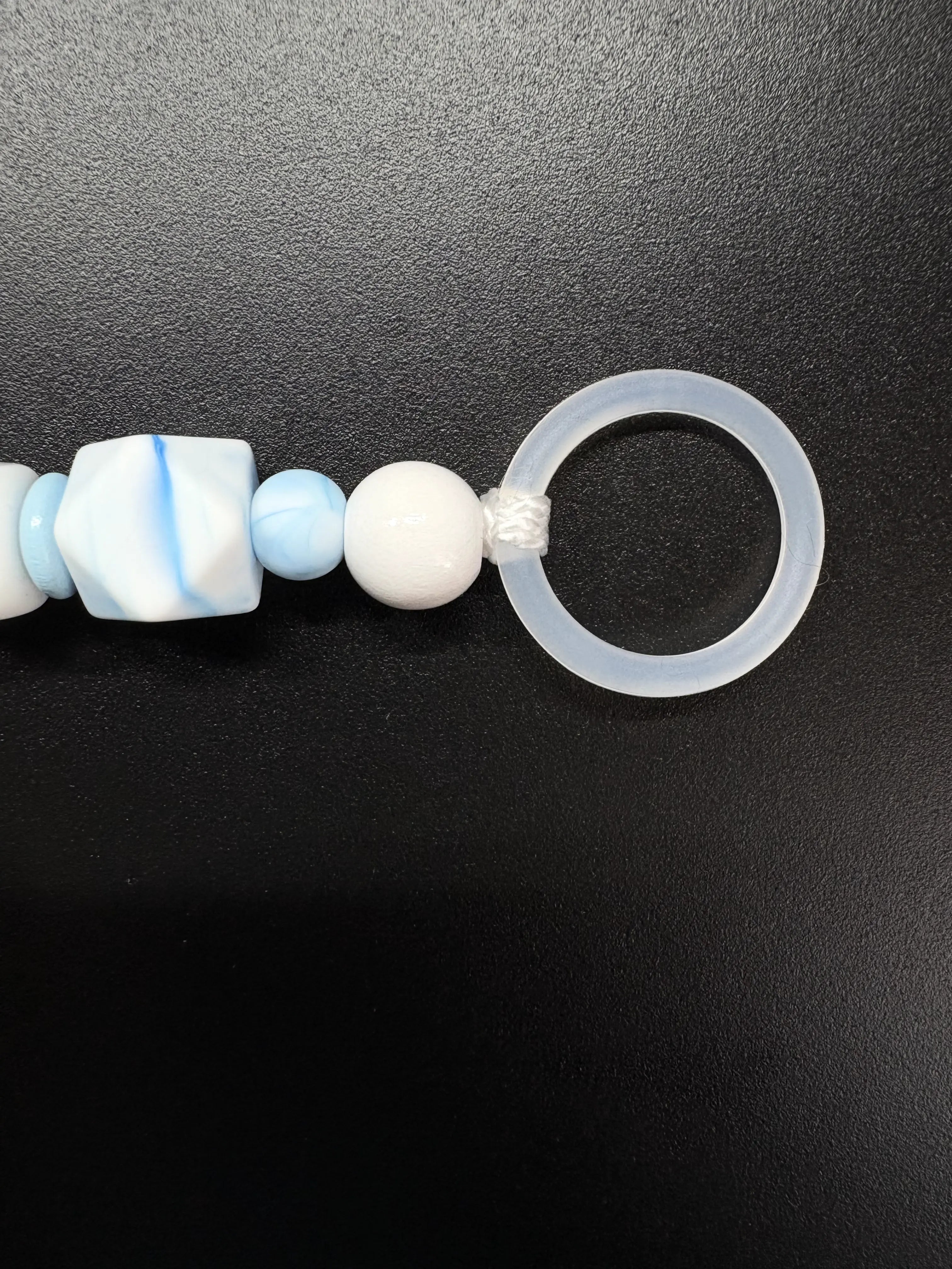 Detailaufnahme des Silikonrings der personalisierten Schnullerkette Elias in Hellblau und Weiß