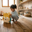 Kind mit gelbem Fuchs Kinderrucksack beim Spielen im Kinderzimmer – ideal für Kindergarten und Ausflüge