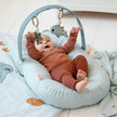 Baby spielt mit Hängespielzeug Wally und Seestern am Aktivitätsbogen auf weicher Spielunterlage