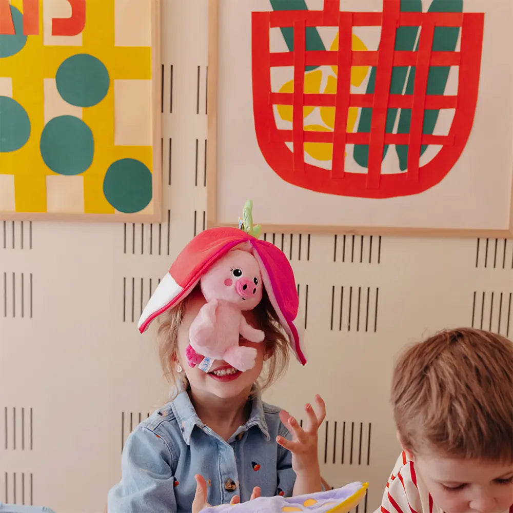 Kind spielt mit einem wandelbaren 2-in-1 Ferkel Plüschtier in Rettich-Optik im Kinderzimmer