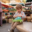 Kind spielt mit 2-in-1 Fisch und Erbsenschote Kuscheltier auf einem Markt