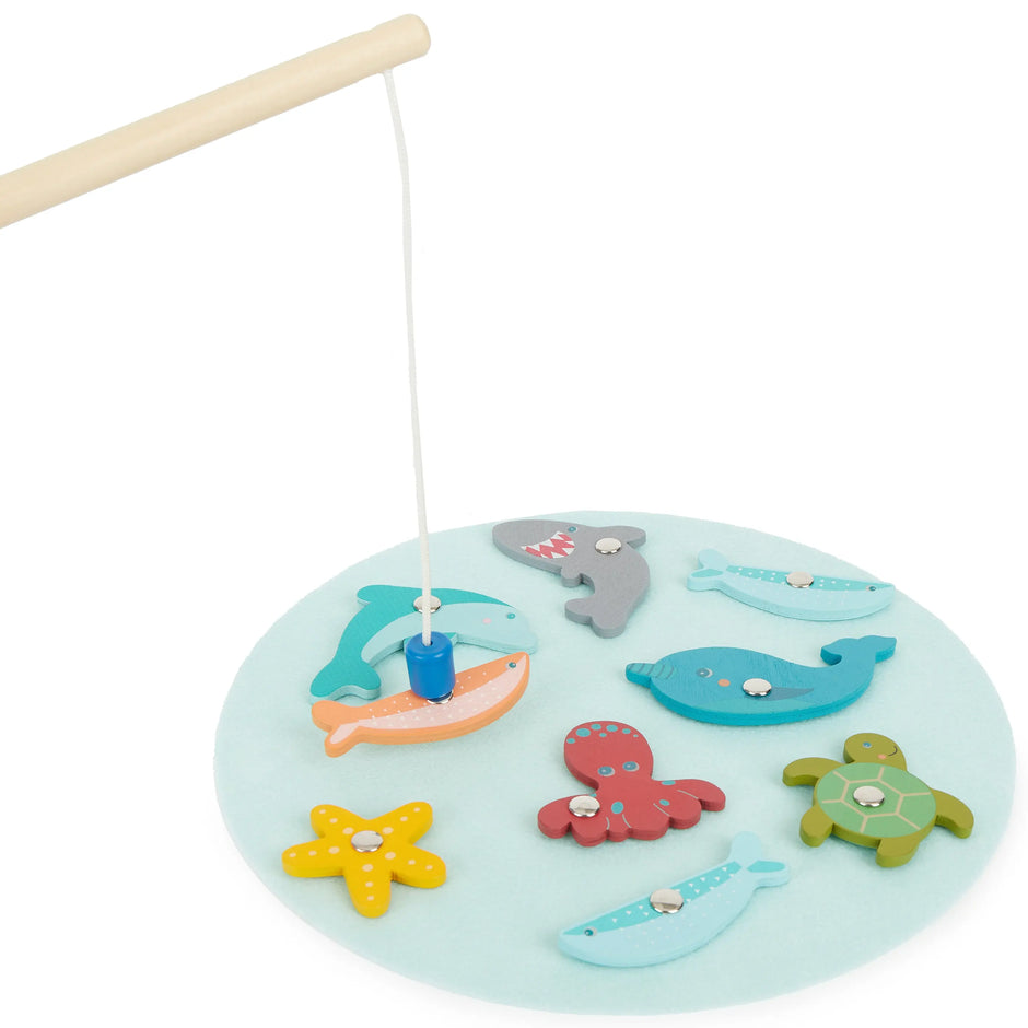 Kind angelt mit Magnet-Angelrute beim Holz Magnet-Angelspiel von Bieco mit bunten Meerestieren – Montessori Lernspiel zur Förderung von Motorik, Konzentration und Geschicklichkeit