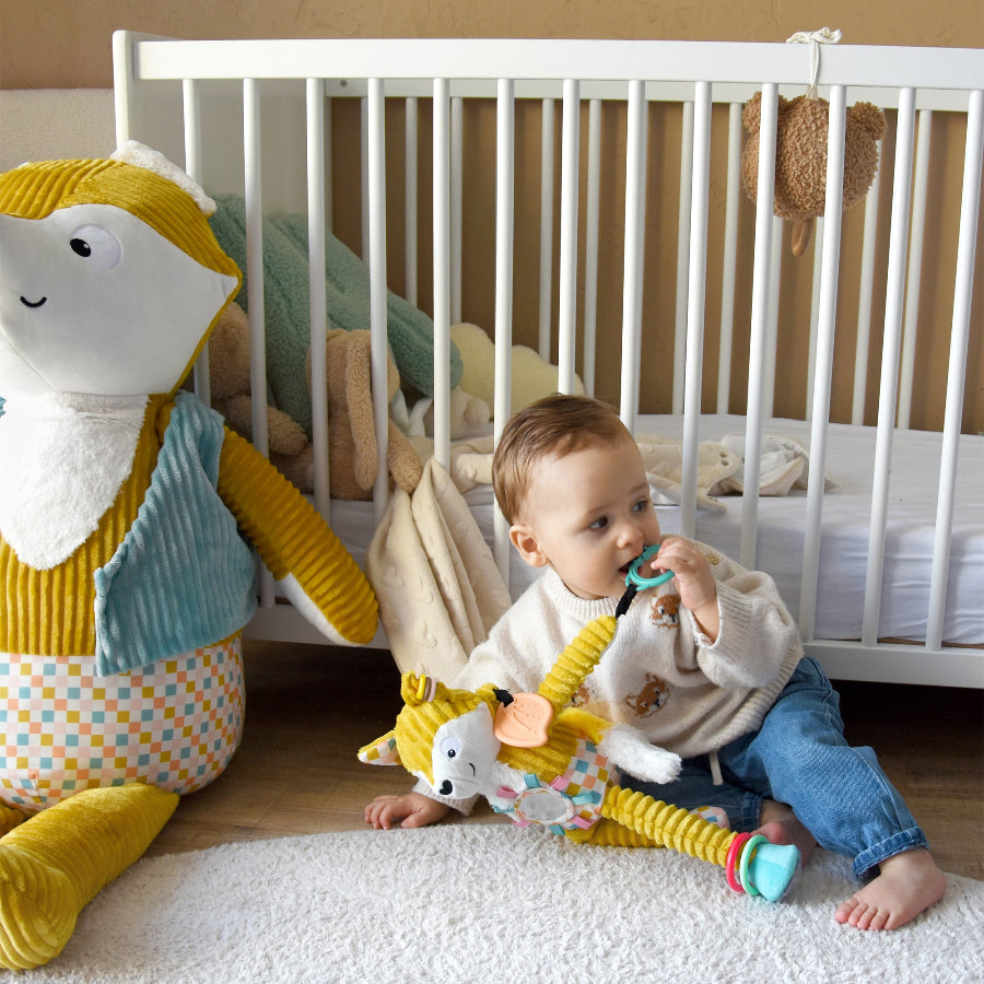 Baby spielt im Kinderzimmer mit Fuchs Activity-Anhänger Cyranos – weiches Activity-Spielzeug mit Beißring und Spiegel, geeignet ab Geburt