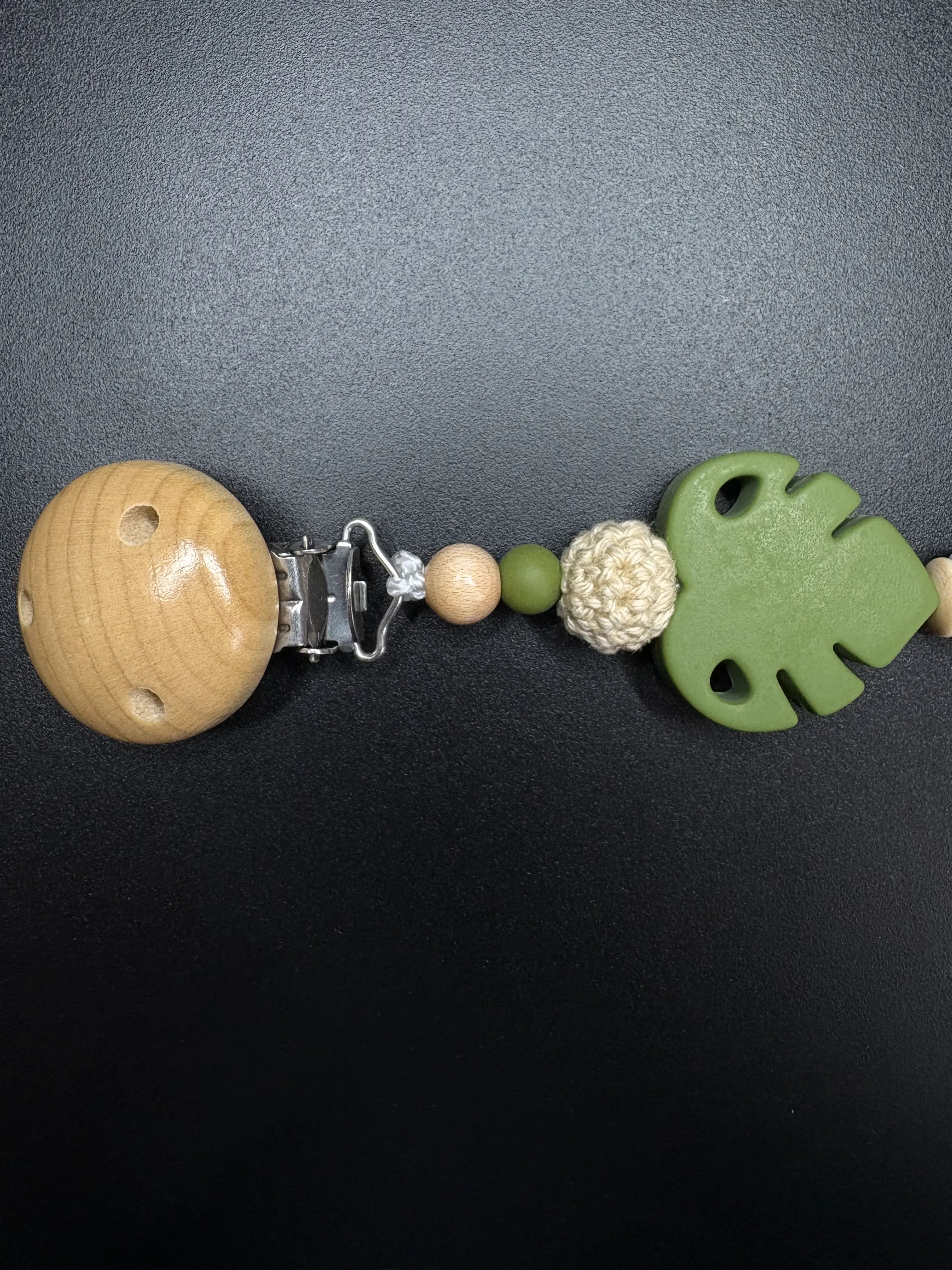 Holzclip mit Monstera-Silikonblatt an personalisierter Schnullerkette in Grün und Naturtönen
