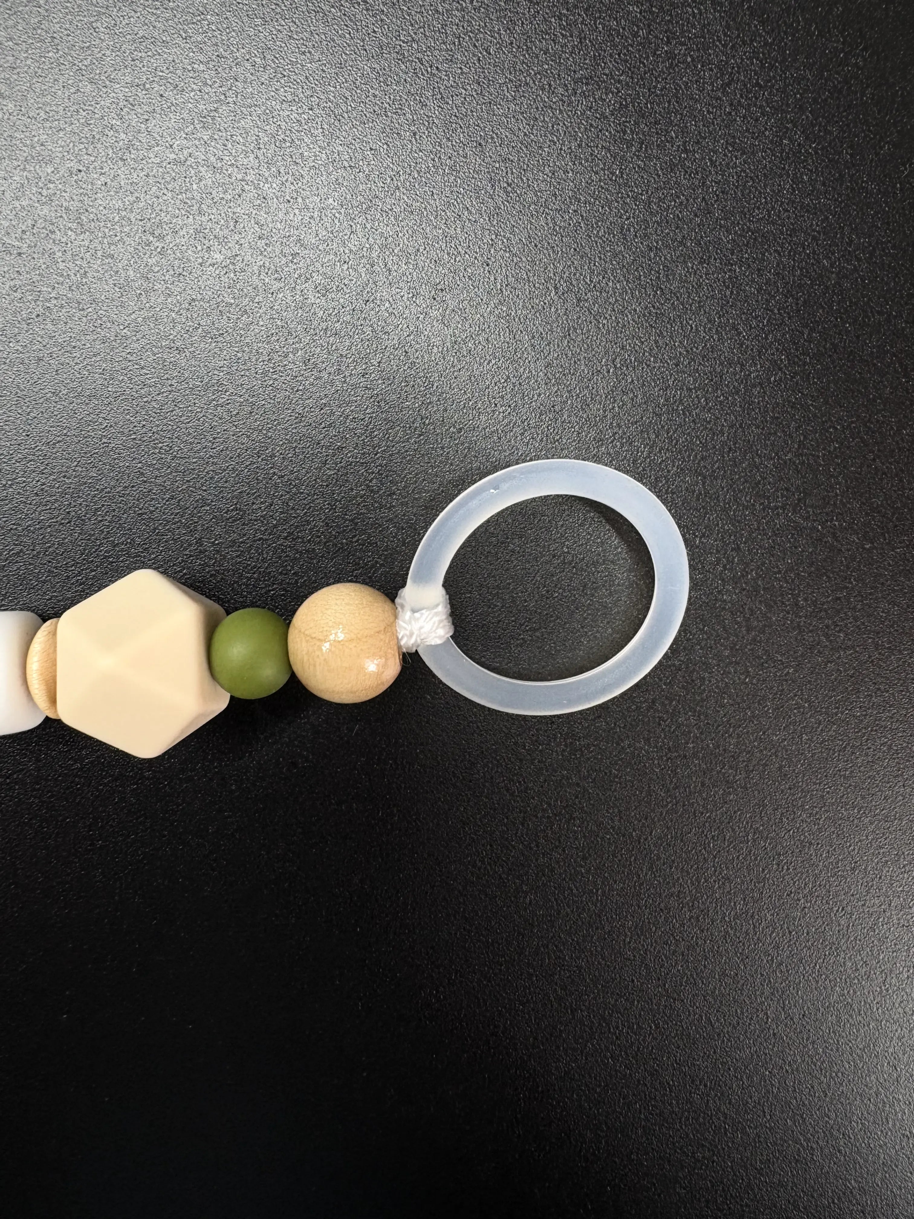 Silikonring und Holzperlen einer personalisierten Schnullerkette in Olivgrün und Beige