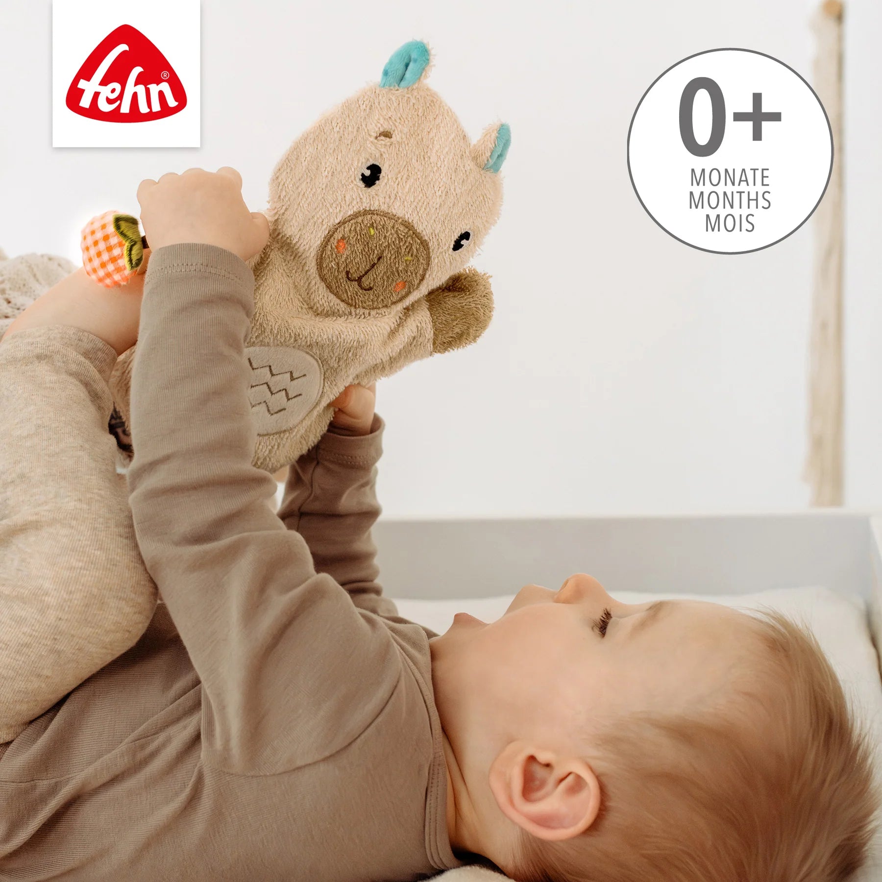 Baby spielt mit weichem Capybara Waschhandschuh von Fehn für Babys ab Geburt